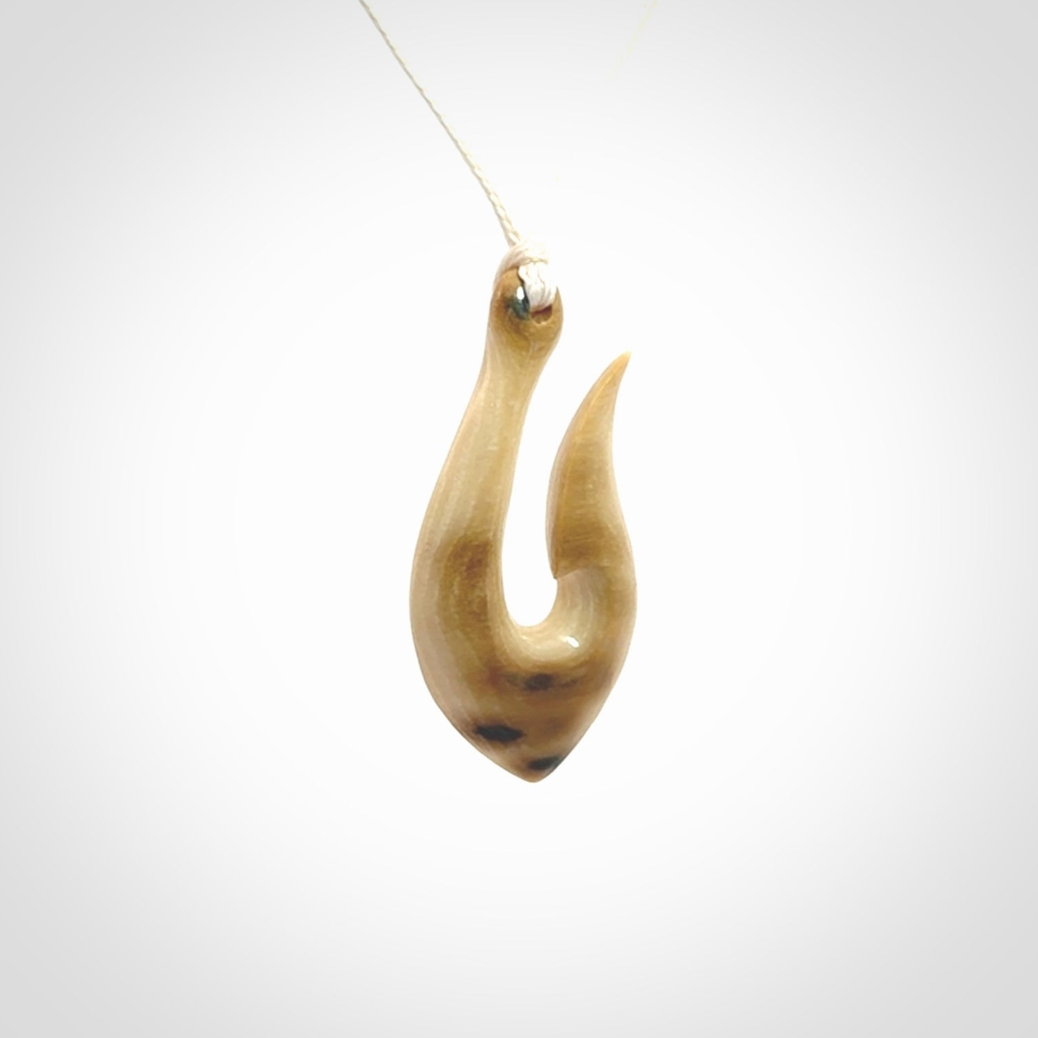 A fish hook necklace (hei-matau) hand-carved in a traditional style from Woolly Mammoth Tusk. These are glorious pieces of art to wear. Provided with adjustable cords and packaged in a woven kete pouch. Delivered with express courier.