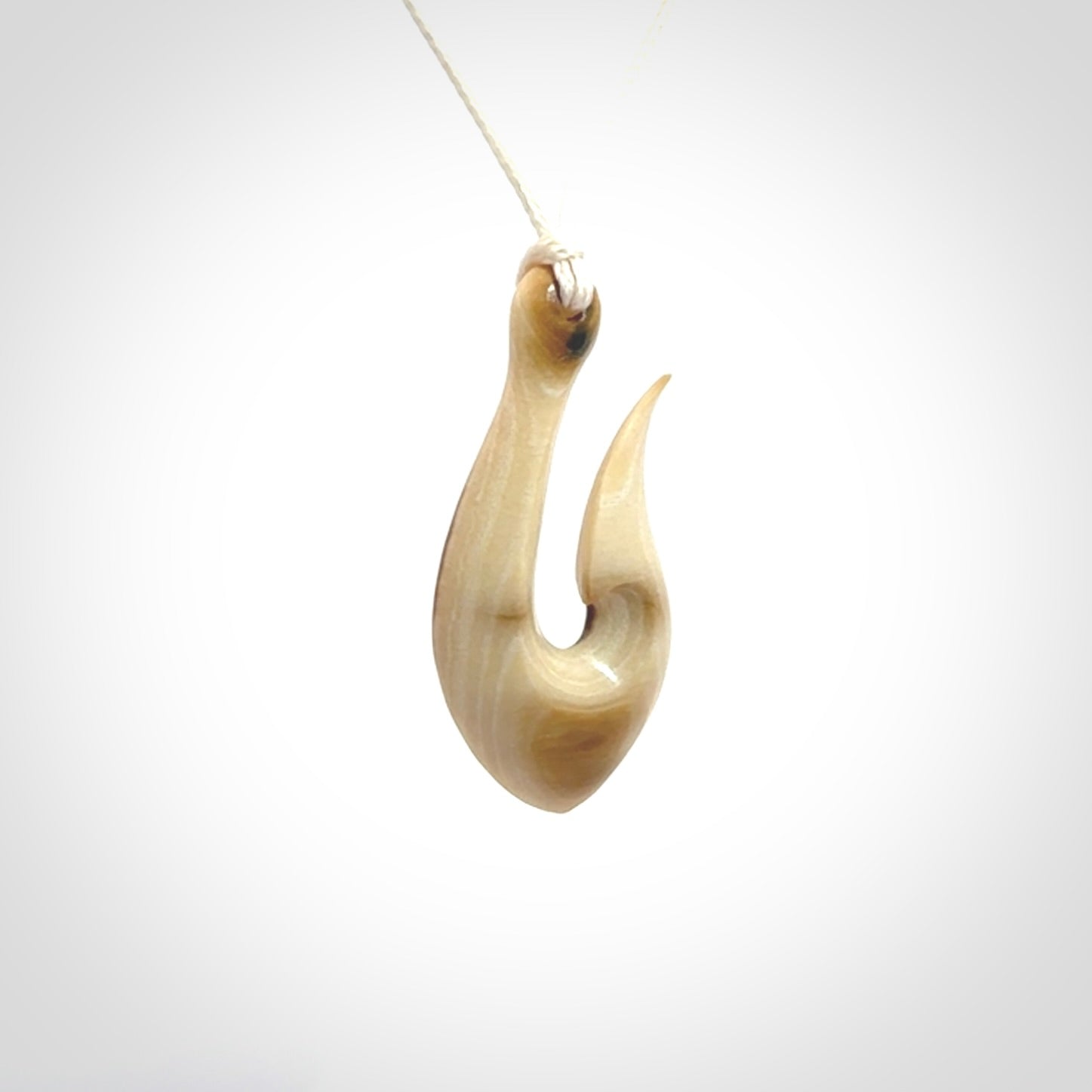 A fish hook necklace (hei-matau) hand-carved in a traditional style from Woolly Mammoth Tusk. These are glorious pieces of art to wear. Provided with adjustable cords and packaged in a woven kete pouch. Delivered with express courier.
