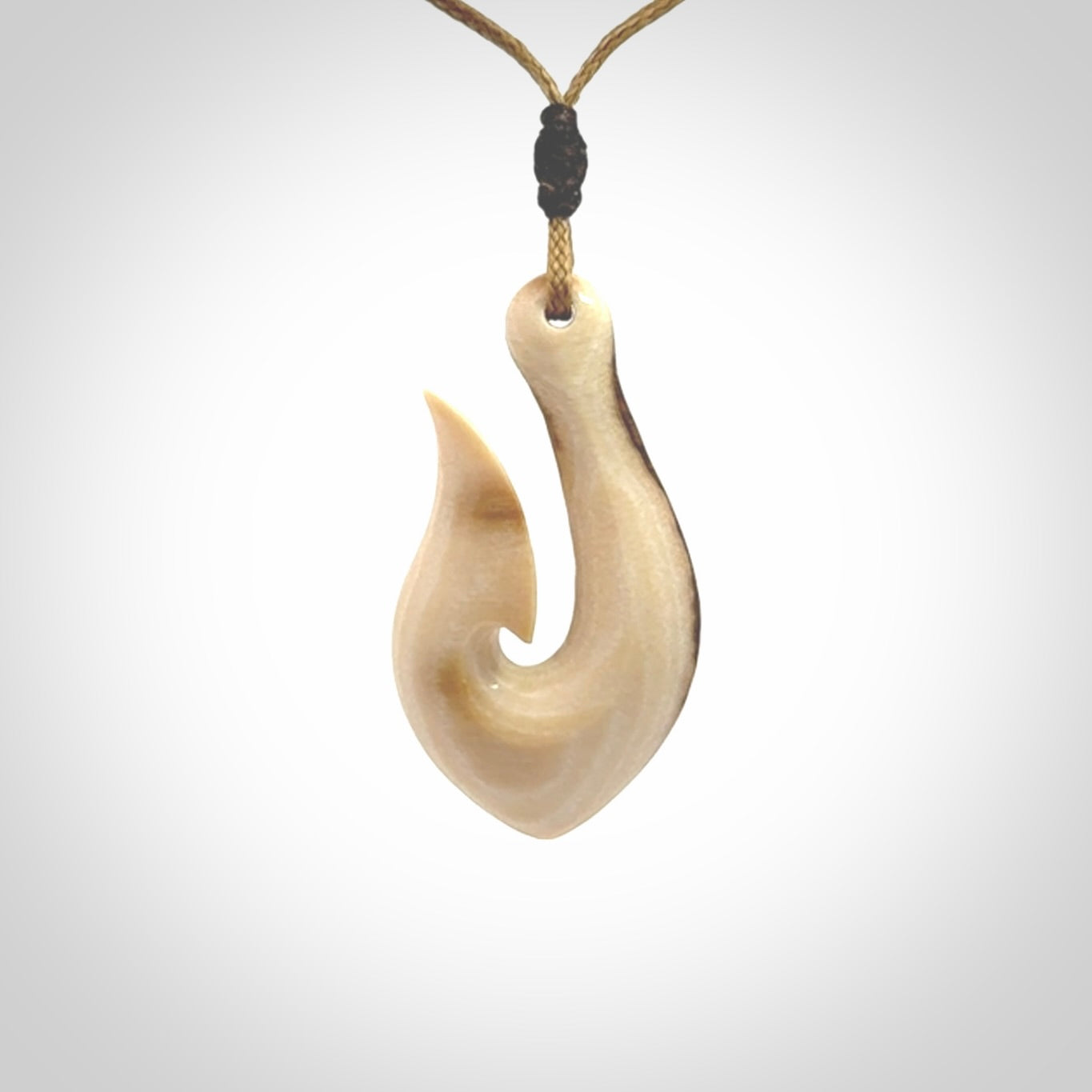 A fish hook necklace (hei-matau) hand-carved in a traditional style from Woolly Mammoth Tusk. These are glorious pieces of art to wear. Provided with adjustable cords and packaged in a woven kete pouch. Delivered with express courier.