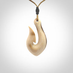 A fish hook necklace (hei-matau) hand-carved in a traditional style from Woolly Mammoth Tusk. These are glorious pieces of art to wear. Provided with adjustable cords and packaged in a woven kete pouch. Delivered with express courier.