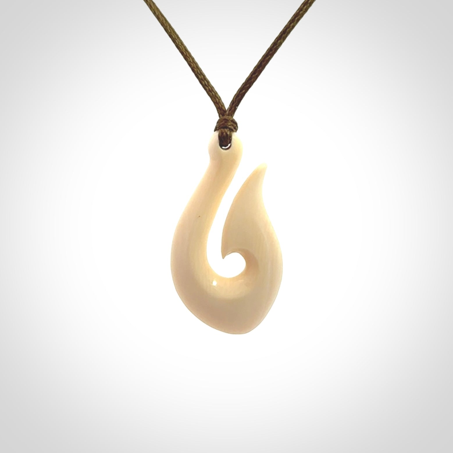 A fish hook necklace (hei-matau) hand-carved in a traditional style from Woolly Mammoth Tusk. These are glorious pieces of art to wear. Provided with adjustable cords and packaged in a woven kete pouch