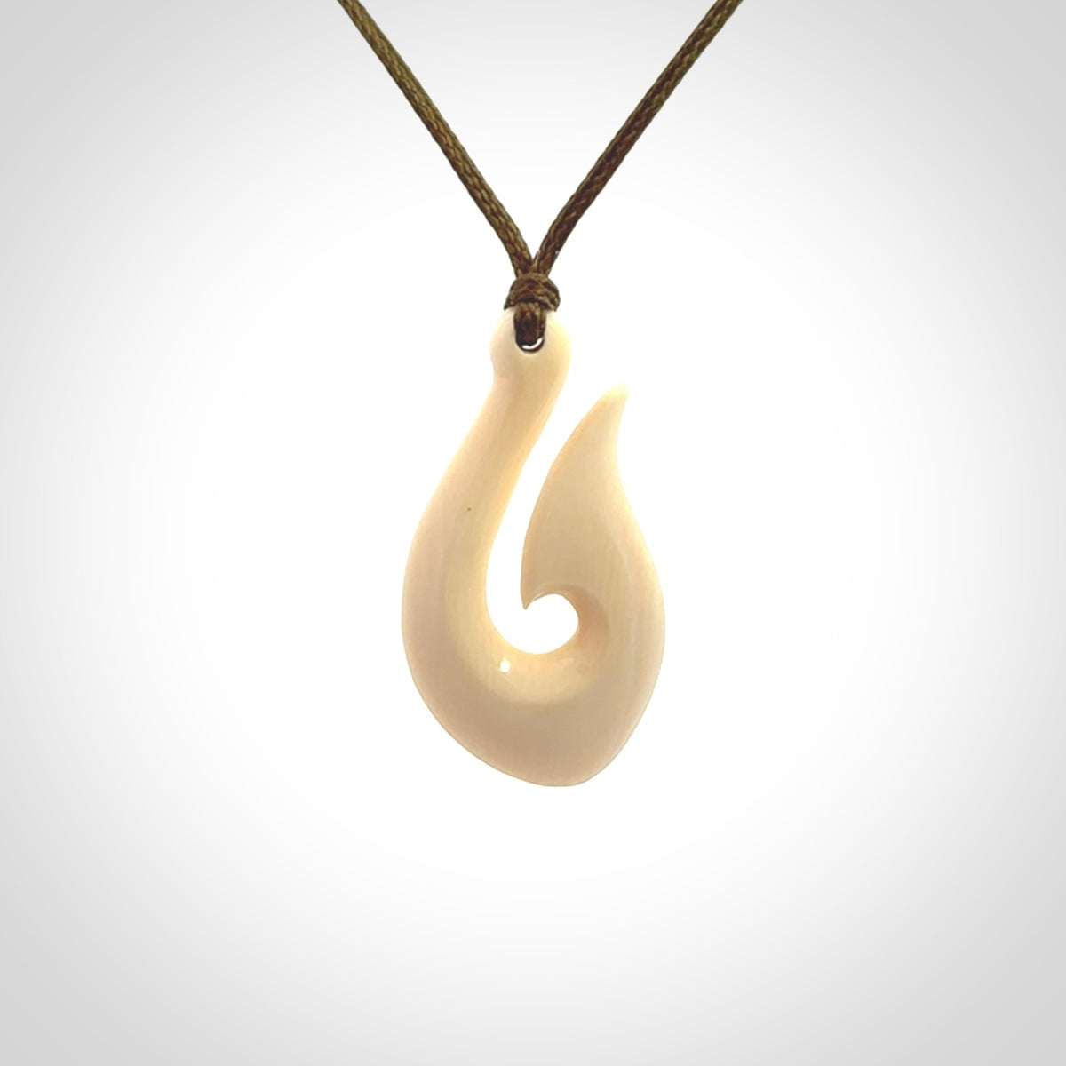 A fish hook necklace (hei-matau) hand-carved in a traditional style from Woolly Mammoth Tusk. These are glorious pieces of art to wear. Provided with adjustable cords and packaged in a woven kete pouch