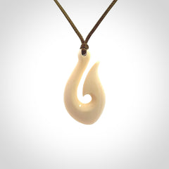 A fish hook necklace (hei-matau) hand-carved in a traditional style from Woolly Mammoth Tusk. These are glorious pieces of art to wear. Provided with adjustable cords and packaged in a woven kete pouch