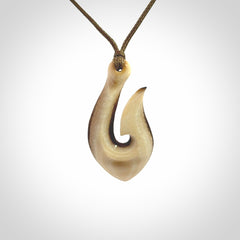 A fish hook necklace (hei-matau) hand-carved in a traditional style from Woolly Mammoth Tusk. These are glorious pieces of art to wear. Provided with adjustable cords and packaged in a woven kete pouch. Delivered with express courier.