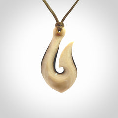 A fish hook necklace (hei-matau) hand-carved in a traditional style from Woolly Mammoth Tusk. These are glorious pieces of art to wear. Provided with adjustable cords and packaged in a woven kete pouch. Delivered with express courier.