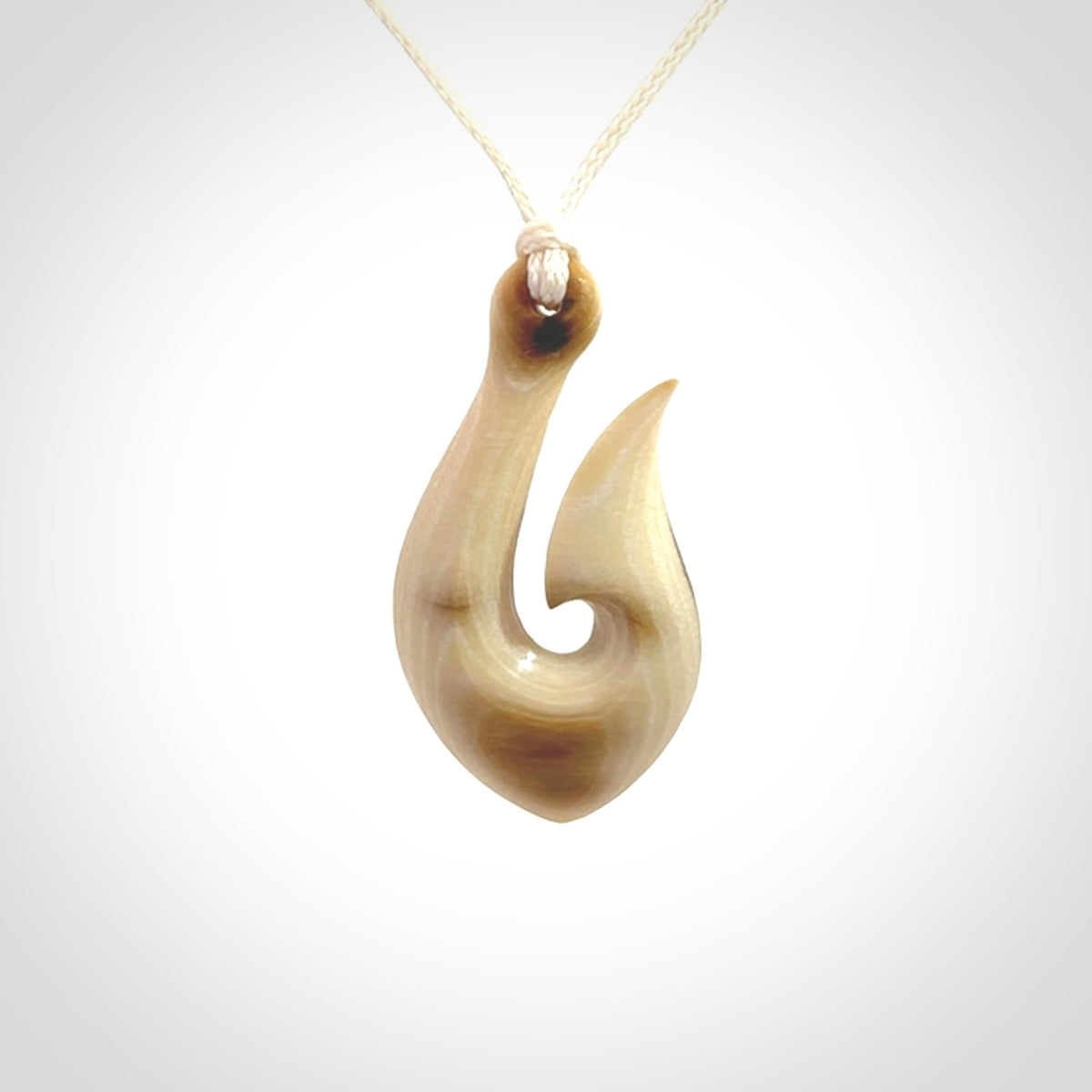 A fish hook necklace (hei-matau) hand-carved in a traditional style from Woolly Mammoth Tusk. These are glorious pieces of art to wear. Provided with adjustable cords and packaged in a woven kete pouch. Delivered with express courier.