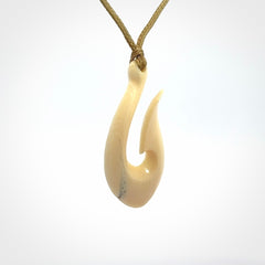 A fish hook necklace (hei-matau) hand-carved in a traditional style from Woolly Mammoth Tusk. These are glorious pieces of art to wear. Provided with adjustable cords and packaged in a woven kete pouch