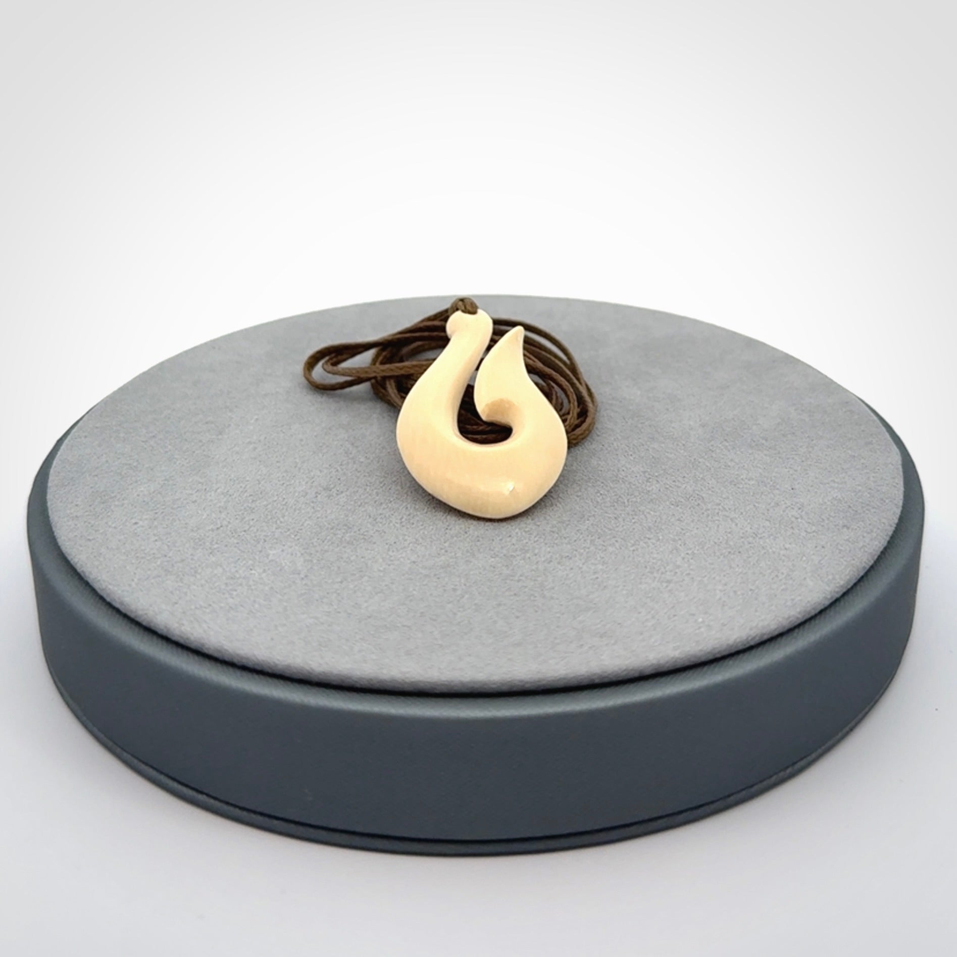 A fish hook necklace (hei-matau) hand-carved in a traditional style from Woolly Mammoth Tusk. These are glorious pieces of art to wear. Provided with adjustable cords and packaged in a woven kete pouch