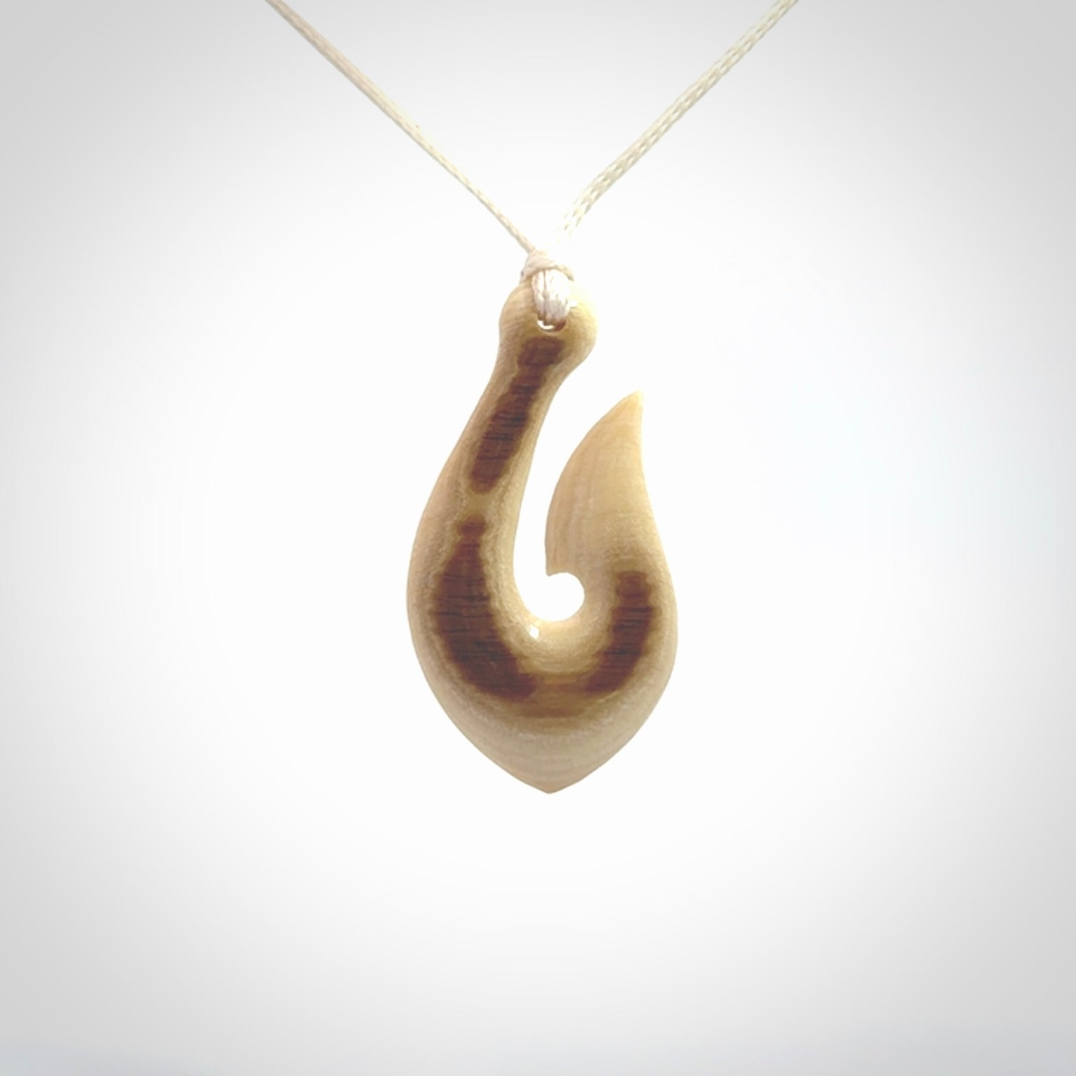A fish hook necklace (hei-matau) hand-carved in a traditional style from Woolly Mammoth Tusk. These are glorious pieces of art to wear. Provided with adjustable cords and packaged in a woven kete pouch. Delivered with express courier.