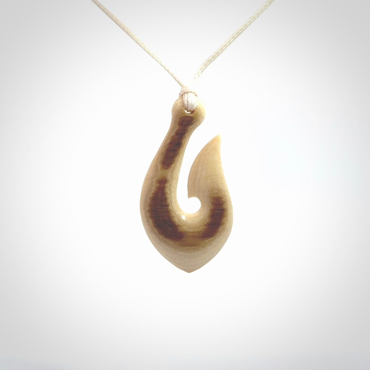 A fish hook necklace (hei-matau) hand-carved in a traditional style from Woolly Mammoth Tusk. These are glorious pieces of art to wear. Provided with adjustable cords and packaged in a woven kete pouch. Delivered with express courier.