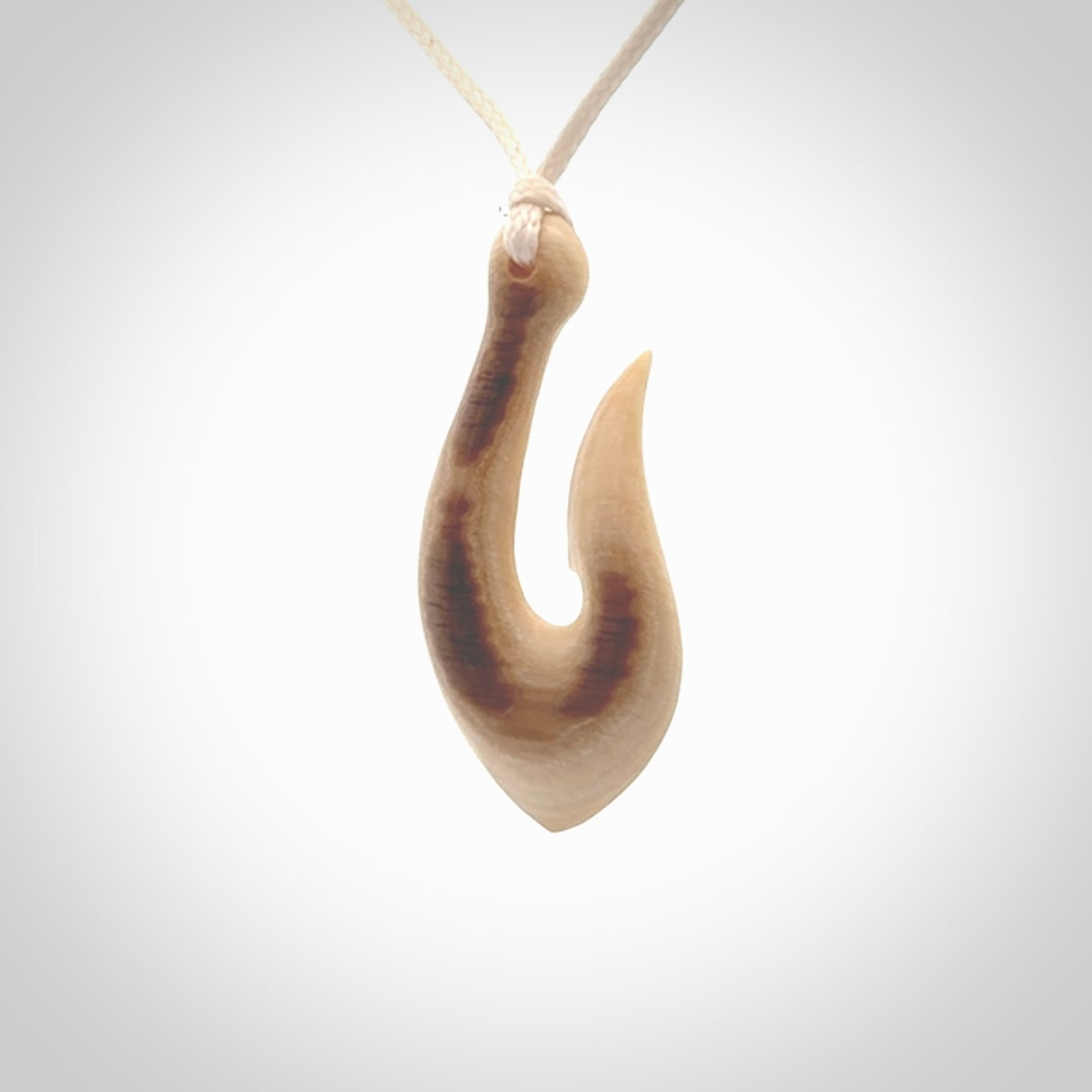 A fish hook necklace (hei-matau) hand-carved in a traditional style from Woolly Mammoth Tusk. These are glorious pieces of art to wear. Provided with adjustable cords and packaged in a woven kete pouch. Delivered with express courier.