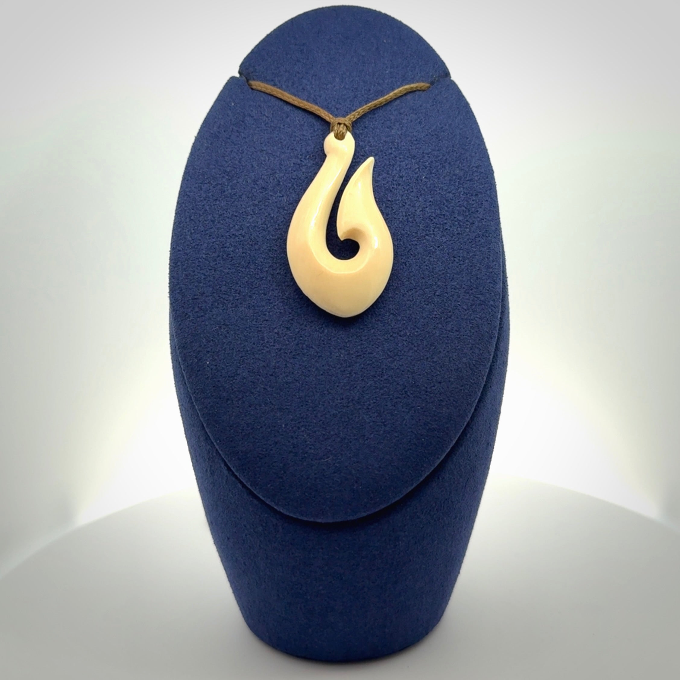 A fish hook necklace (hei-matau) hand-carved in a traditional style from Woolly Mammoth Tusk. These are glorious pieces of art to wear. Provided with adjustable cords and packaged in a woven kete pouch