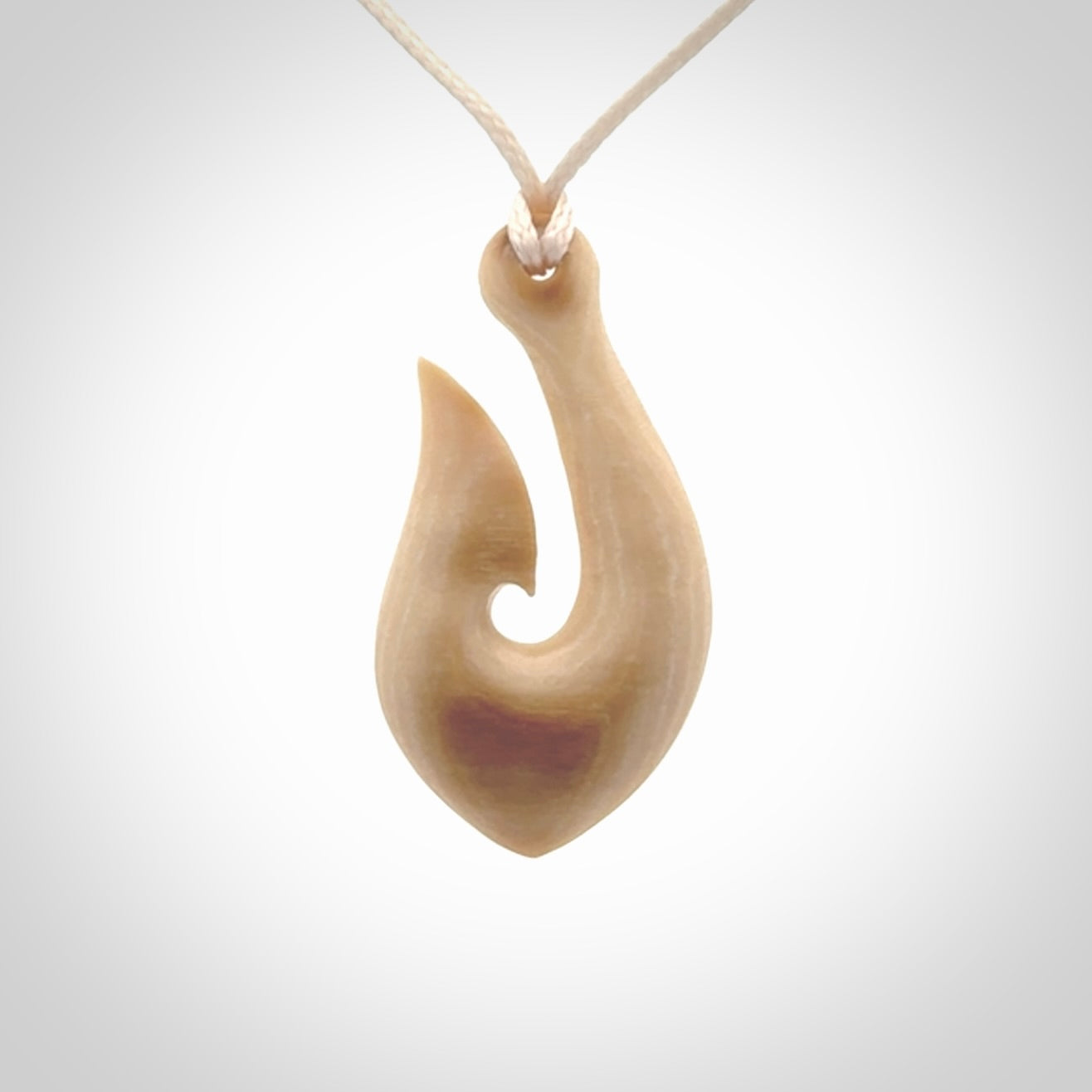 A fish hook necklace (hei-matau) hand-carved in a traditional style from Woolly Mammoth Tusk. These are glorious pieces of art to wear. Provided with adjustable cords and packaged in a woven kete pouch. Delivered with express courier.