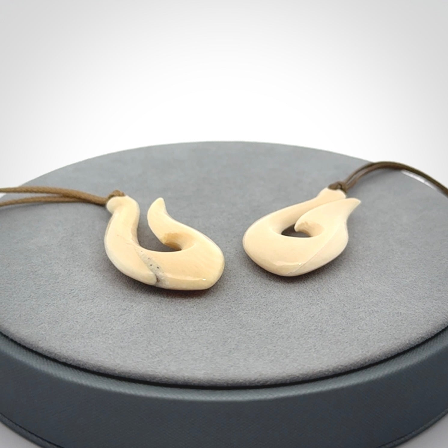 A fish hook necklace (hei-matau) hand-carved in a traditional style from Woolly Mammoth Tusk. These are glorious pieces of art to wear. Provided with adjustable cords and packaged in a woven kete pouch