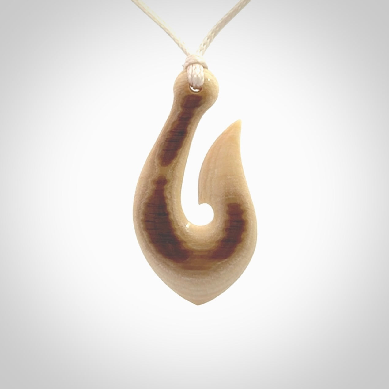A fish hook necklace (hei-matau) hand-carved in a traditional style from Woolly Mammoth Tusk. These are glorious pieces of art to wear. Provided with adjustable cords and packaged in a woven kete pouch. Delivered with express courier.