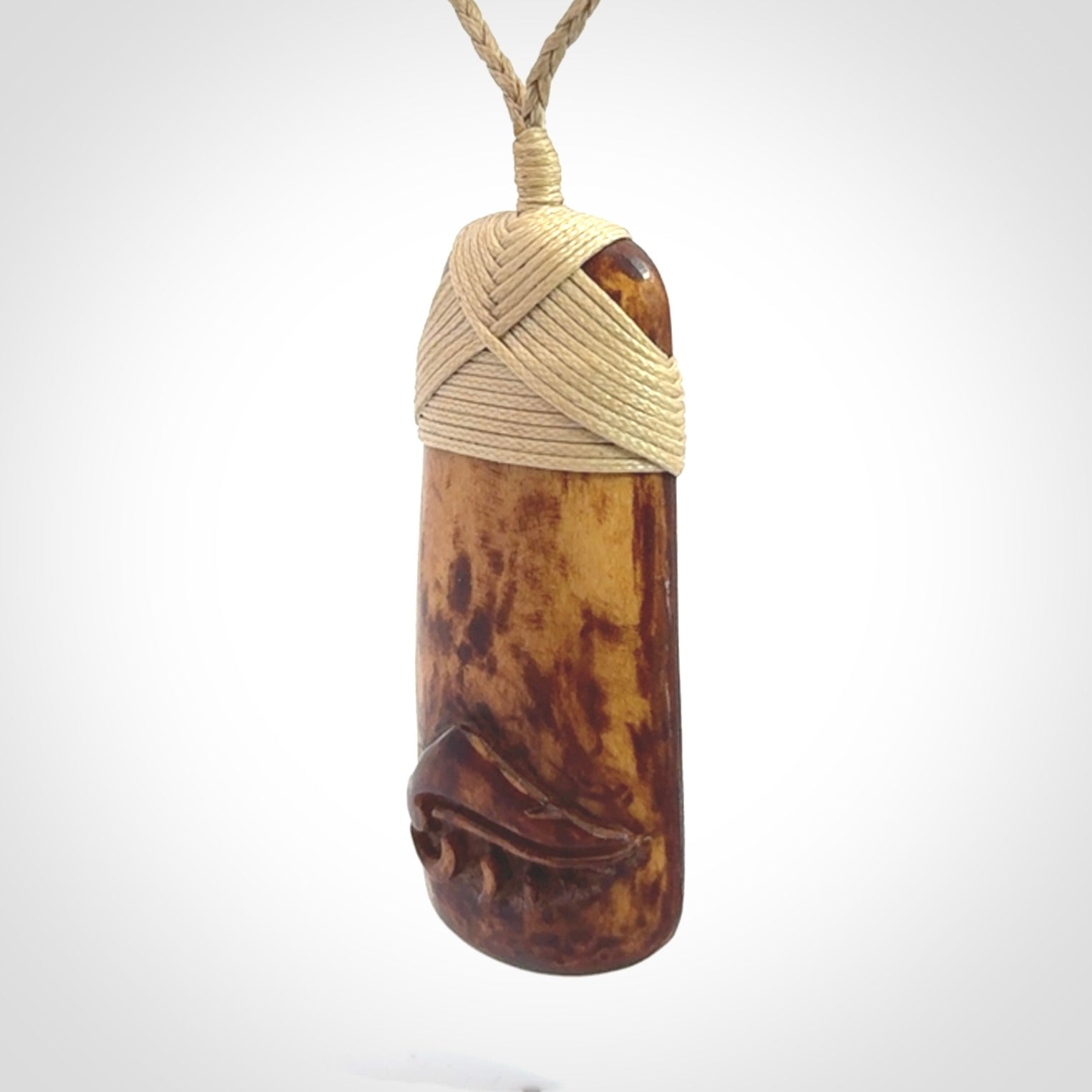 A hand carved bone toki pendant with NZ Pacific logo engraving. These have been stained with our home made tea dye. Unique hand made jewellery from New Zealand Pacific.