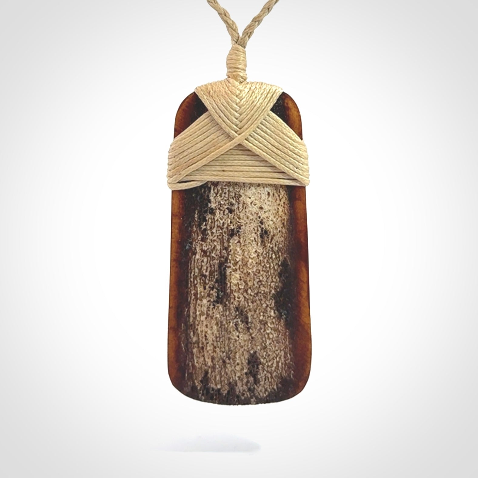 A hand carved bone toki pendant with NZ Pacific logo engraving. These have been stained with our home made tea dye. Unique hand made jewellery from New Zealand Pacific.