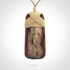 A hand carved bone toki pendant with NZ Pacific logo engraving. These have been stained with our home made tea dye. Unique hand made jewellery from New Zealand Pacific.