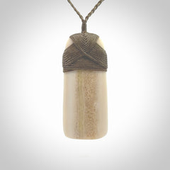 A hand carved bone toki with NZ Pacific logo engraving. Unique hand made jewellery from New Zealand Pacific.