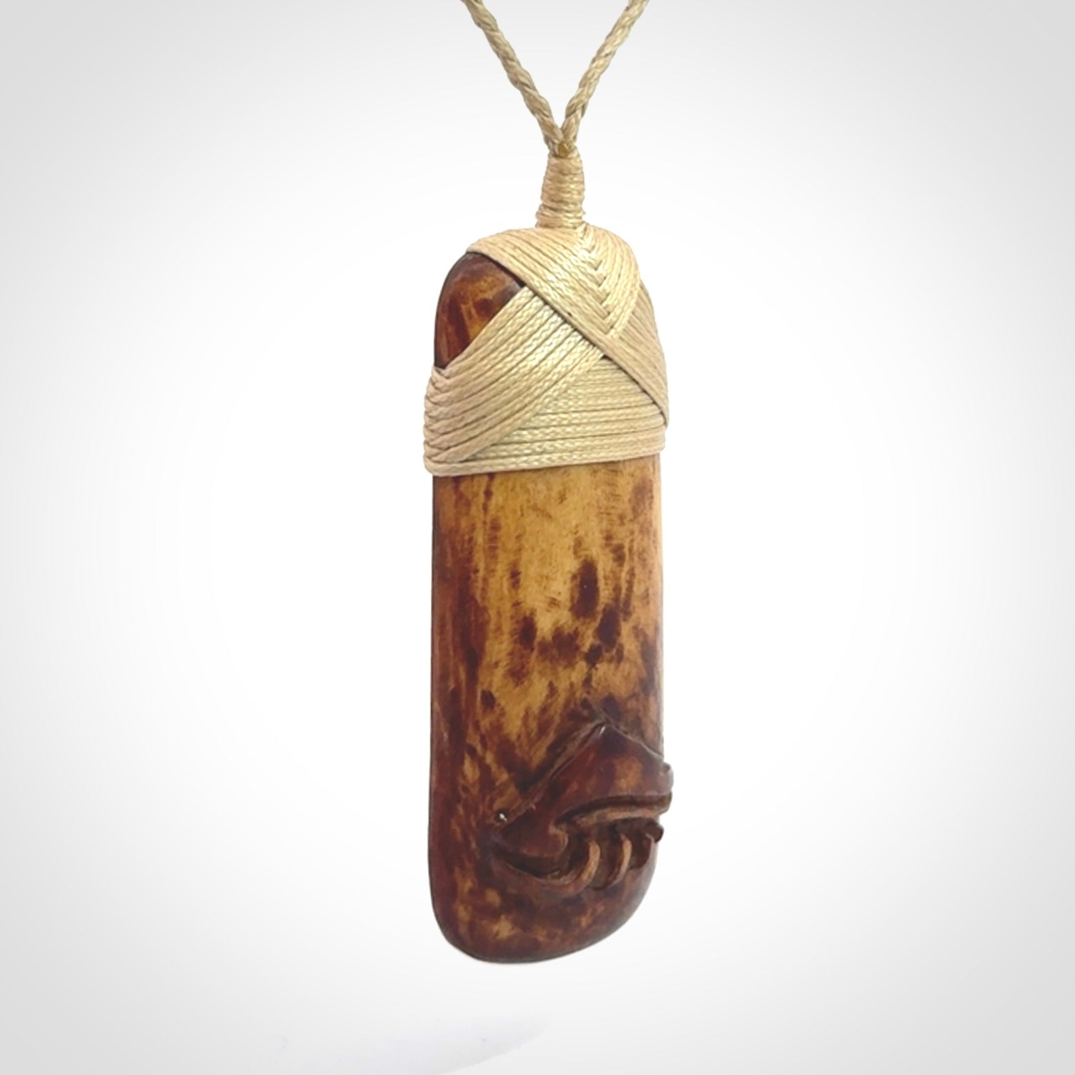 A hand carved bone toki pendant with NZ Pacific logo engraving. These have been stained with our home made tea dye. Unique hand made jewellery from New Zealand Pacific.