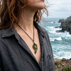 Person wearing jade whale tail pendant