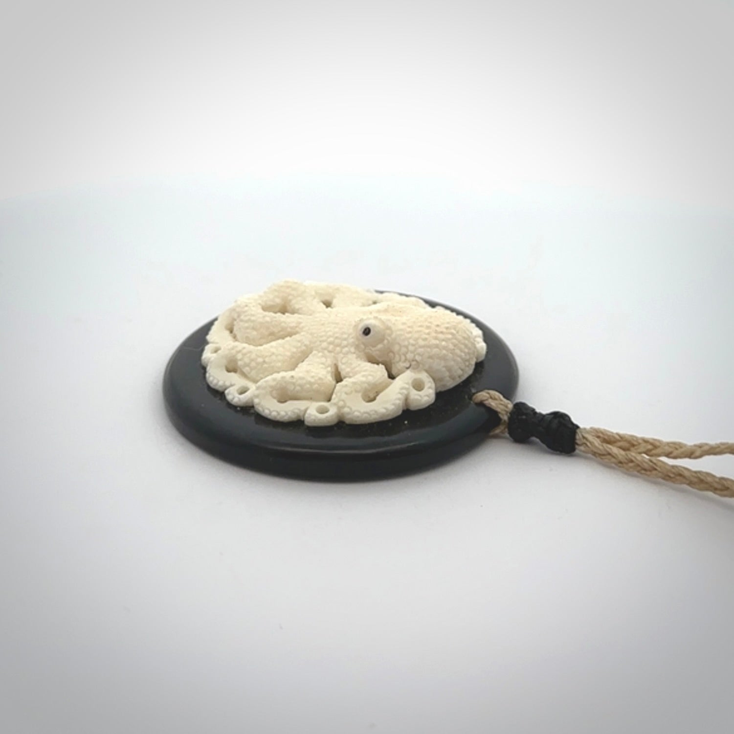 This is a magnificent hand carved octopus pendant. Hand carved in Bone with Black Jade. Provided with an adjustable cord. Hand made octopus pendant.