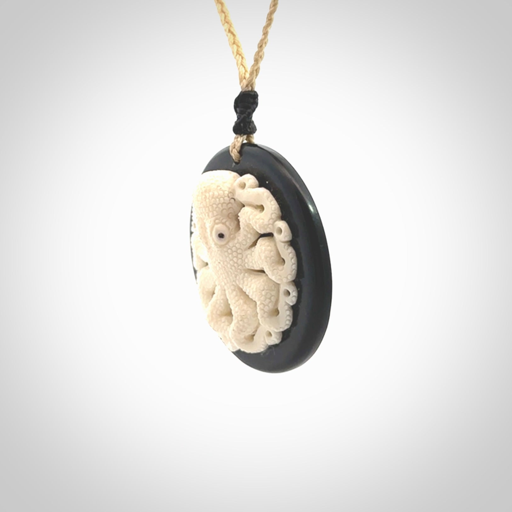 This is a magnificent hand carved octopus pendant. Hand carved in Bone with Black Jade. Provided with an adjustable cord. Hand made octopus pendant.