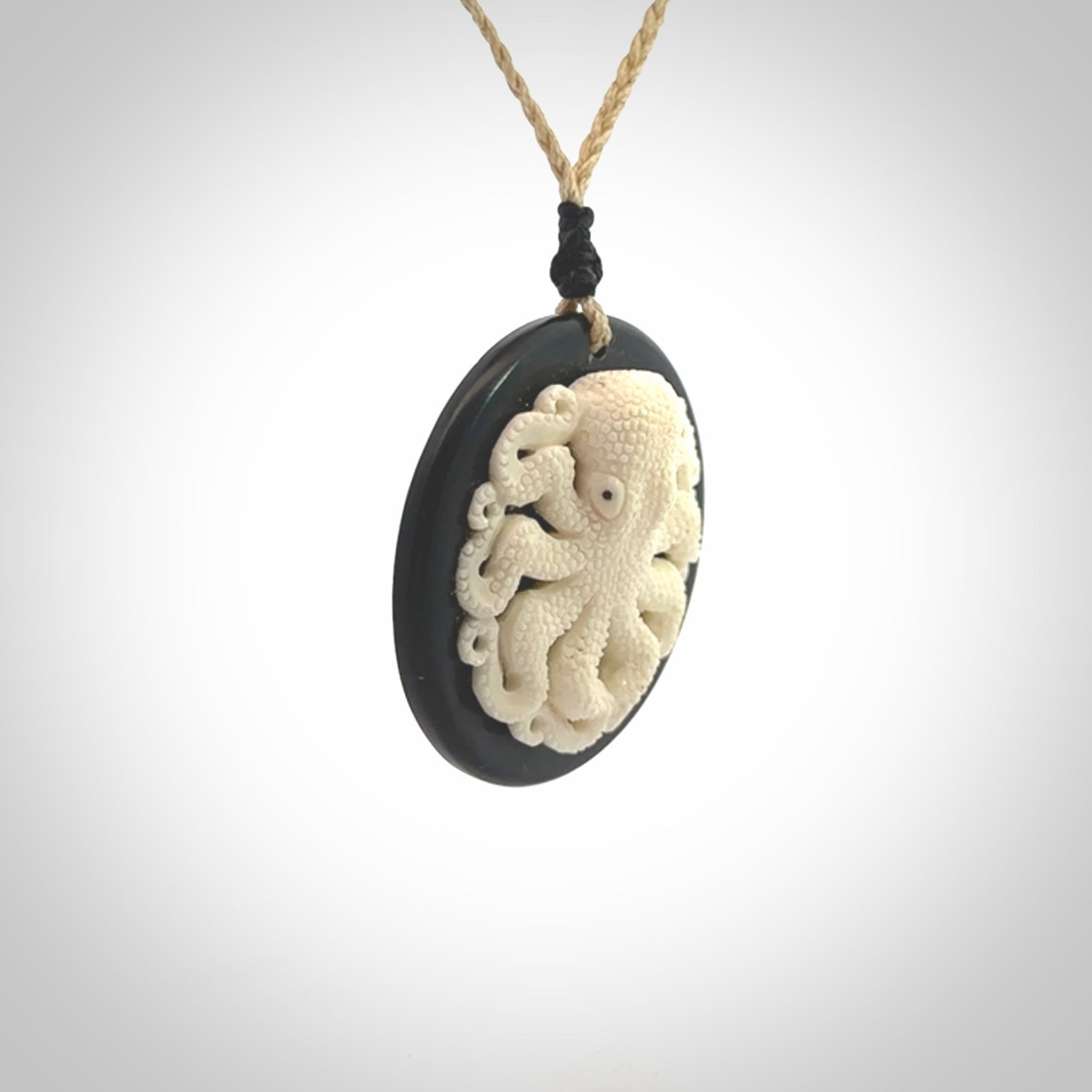 This is a magnificent hand carved octopus pendant. Hand carved in Bone with Black Jade. Provided with an adjustable cord. Hand made octopus pendant.