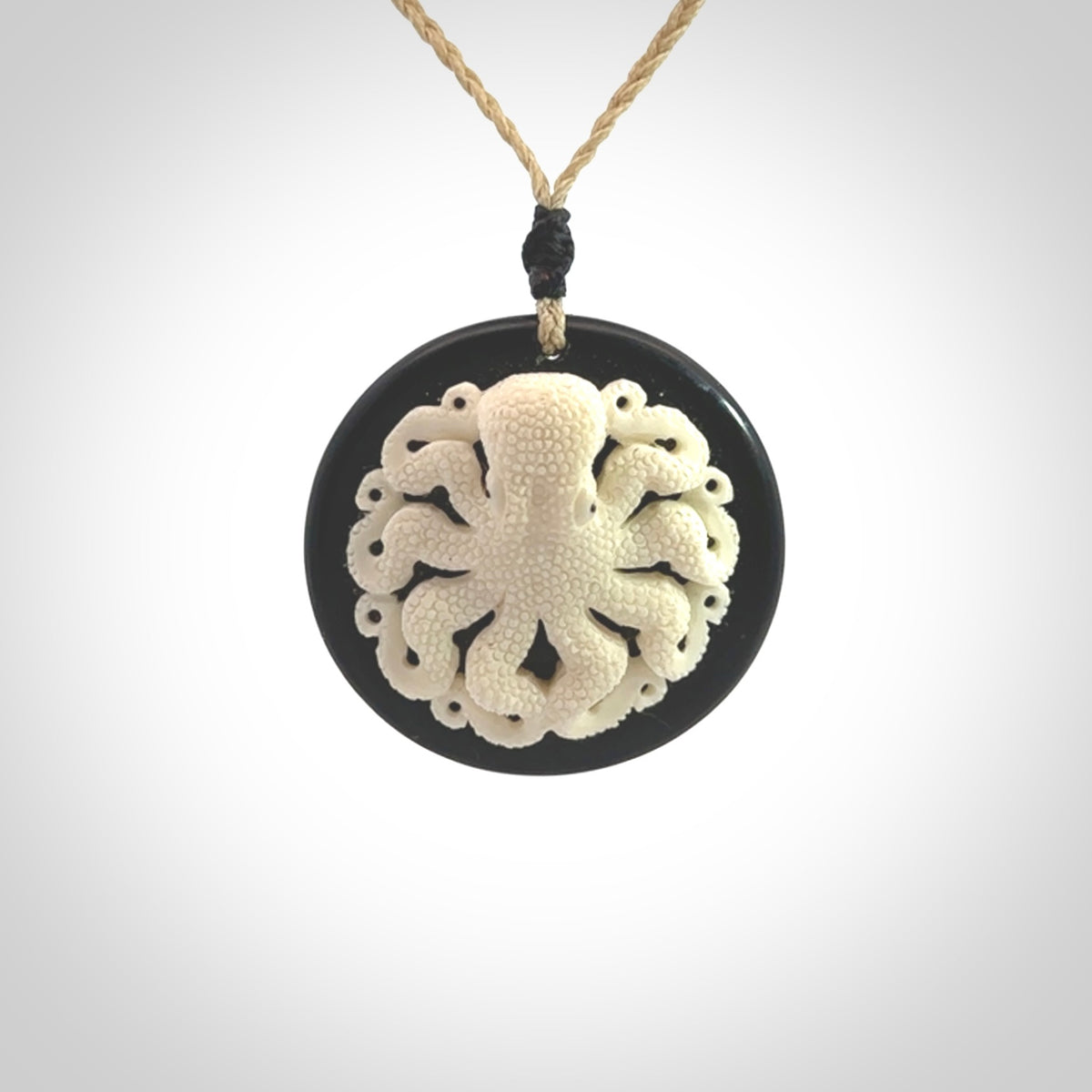 This is a magnificent hand carved octopus pendant. Hand carved in Bone with Black Jade. Provided with an adjustable cord. Hand made octopus pendant.