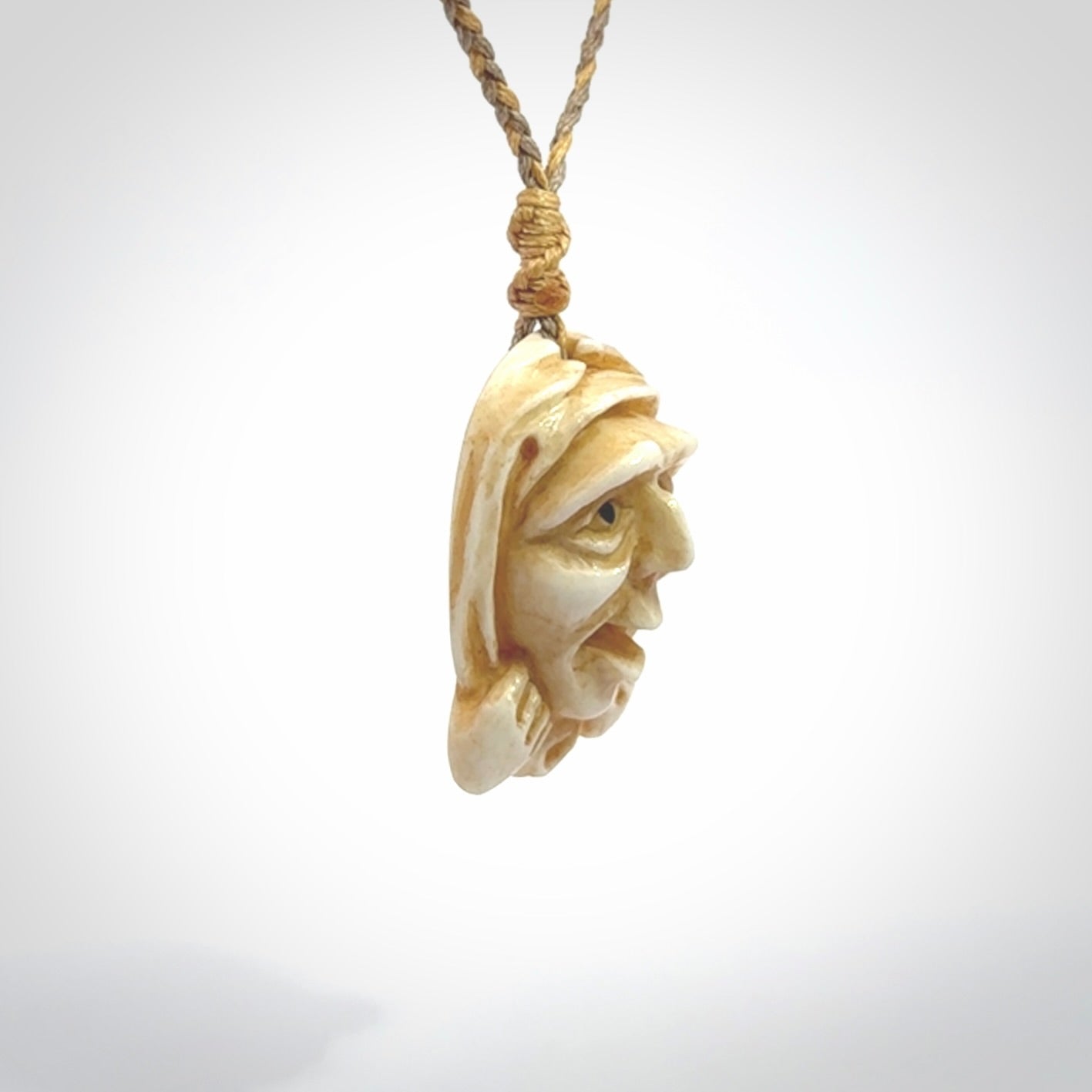 Hand carved incredible stained bone gargoyle face carving. A stunning work of art. This pendant was hand carved in bone with buffalo horn inlay for the eyes by Yuri Terenyi. A one off collectors item that has been hand crafted to be worn or displayed.