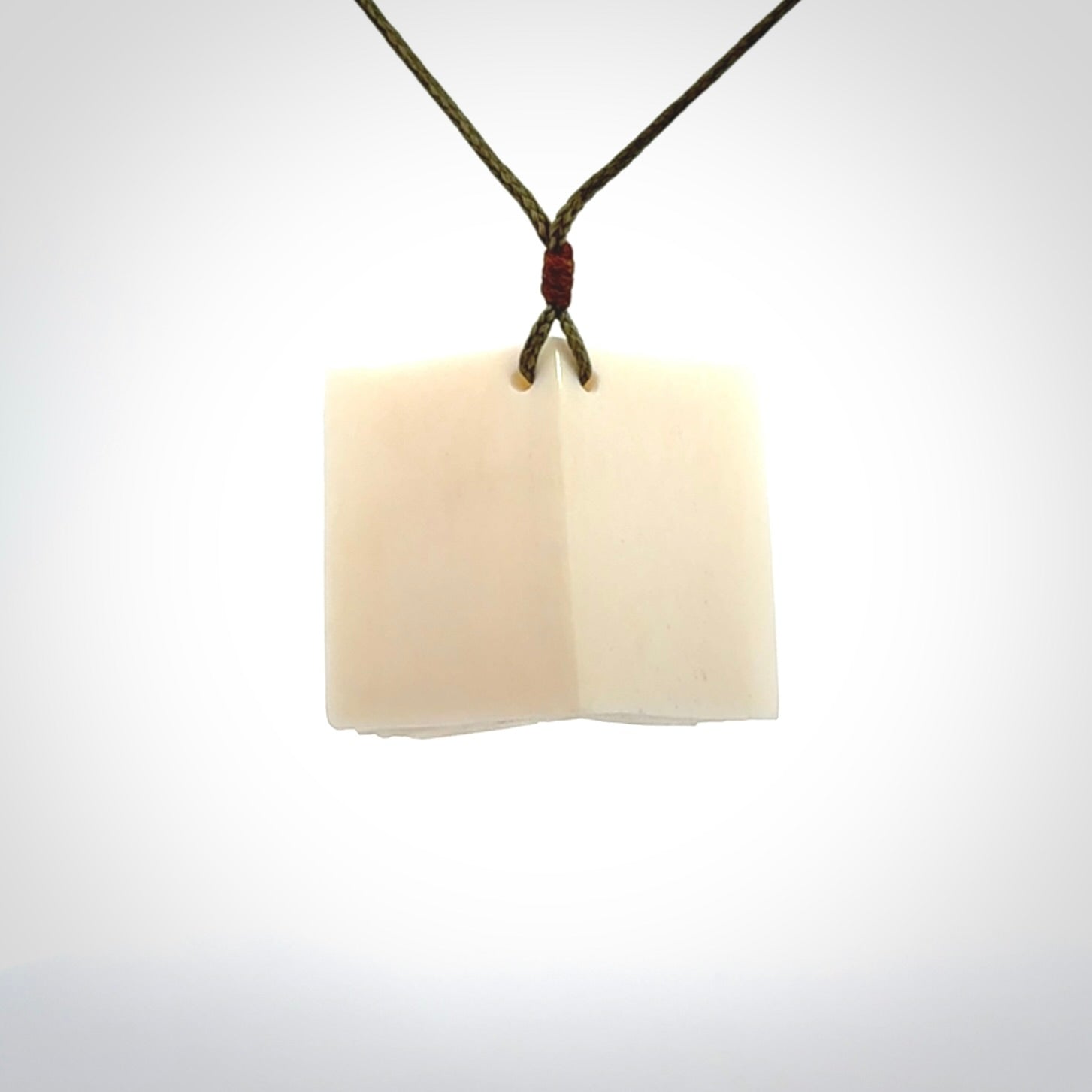 Hand carved open book pendant, hand made in bone.