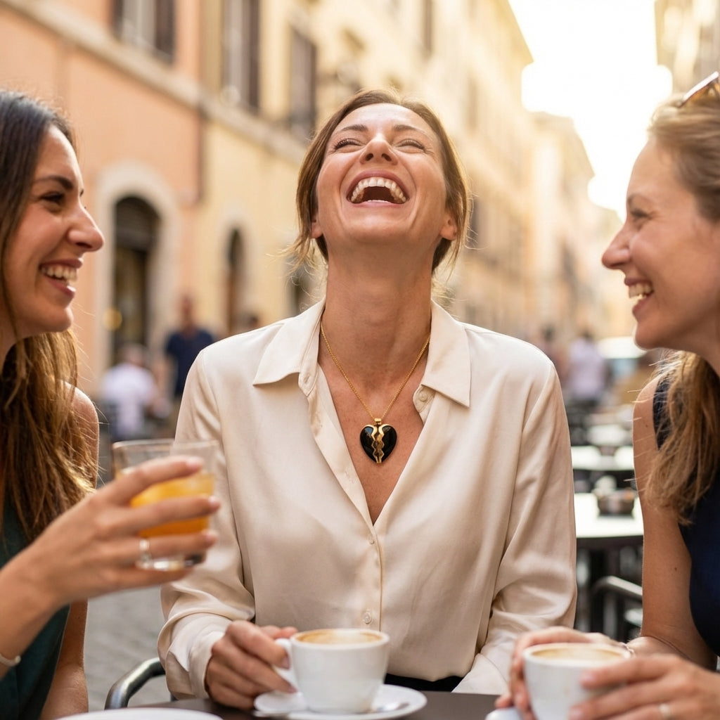 Three women laughing together outdoors, one wearing black jade heart necklace