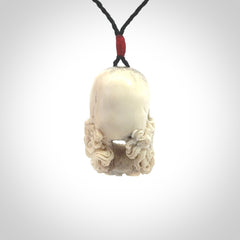 This picture shows a medium sized Deer Antler Bone pirate skull pendant that we have hand carved. The cord is a black colour and has a small red binding just above the pendant.