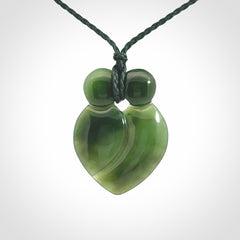 This picture shows a stylised couple in a close embrace sharing a kiss. The pendant is hand carved from a bright faultless piece of British Columbian jade. The cord is a 3-ply plaited green which is adjustable.