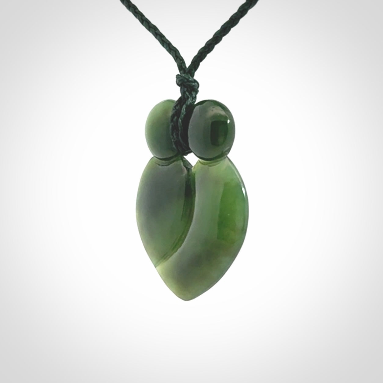This picture shows a stylised couple in a close embrace sharing a kiss. The pendant is hand carved from a bright faultless piece of British Columbian jade. The cord is a 3-ply plaited green which is adjustable.