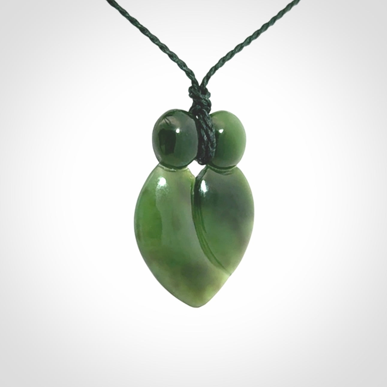 This picture shows a stylised couple in a close embrace sharing a kiss. The pendant is hand carved from a bright faultless piece of British Columbian jade. The cord is a 3-ply plaited green which is adjustable.