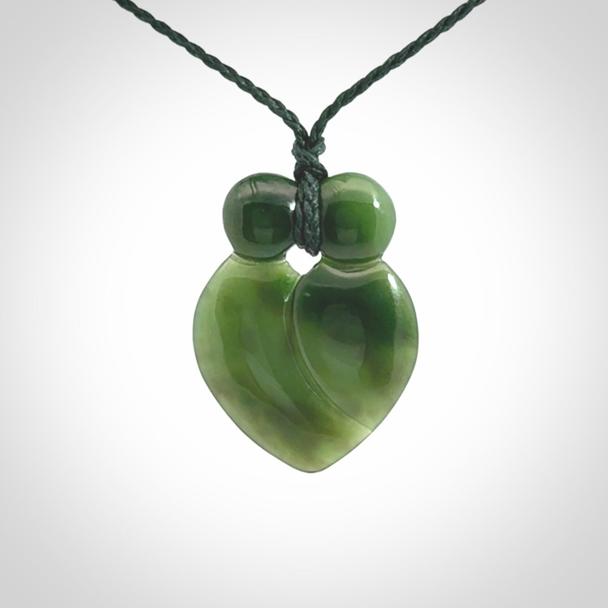 This picture shows a stylised couple in a close embrace sharing a kiss. The pendant is hand carved from a bright faultless piece of British Columbian jade. The cord is a 3-ply plaited green which is adjustable.