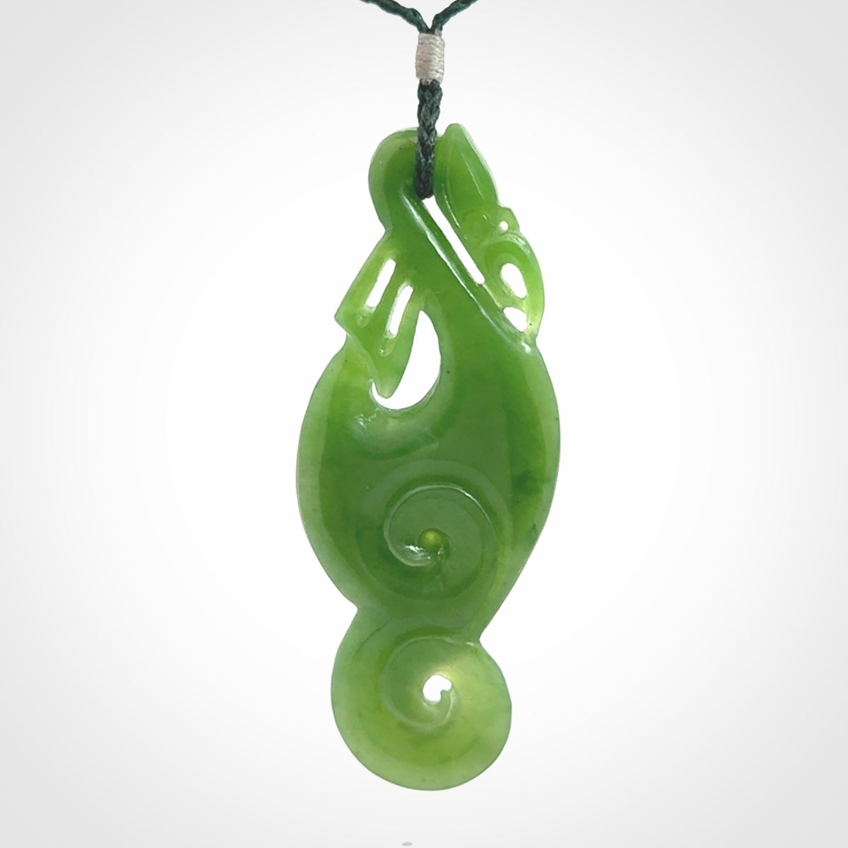This pendant is a beautiful large New Zealand Auhunga green jade manaia pendant with koru. It has the head of a bird and the tail of a fish and also two koru carved into the body. It is carved by Ross Crump here in New Zealand. Provided with an adjustable manuka green cord.