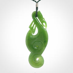 This pendant is a beautiful large New Zealand Auhunga green jade manaia pendant with koru. It has the head of a bird and the tail of a fish and also two koru carved into the body. It is carved by Ross Crump here in New Zealand. Provided with an adjustable manuka green cord.