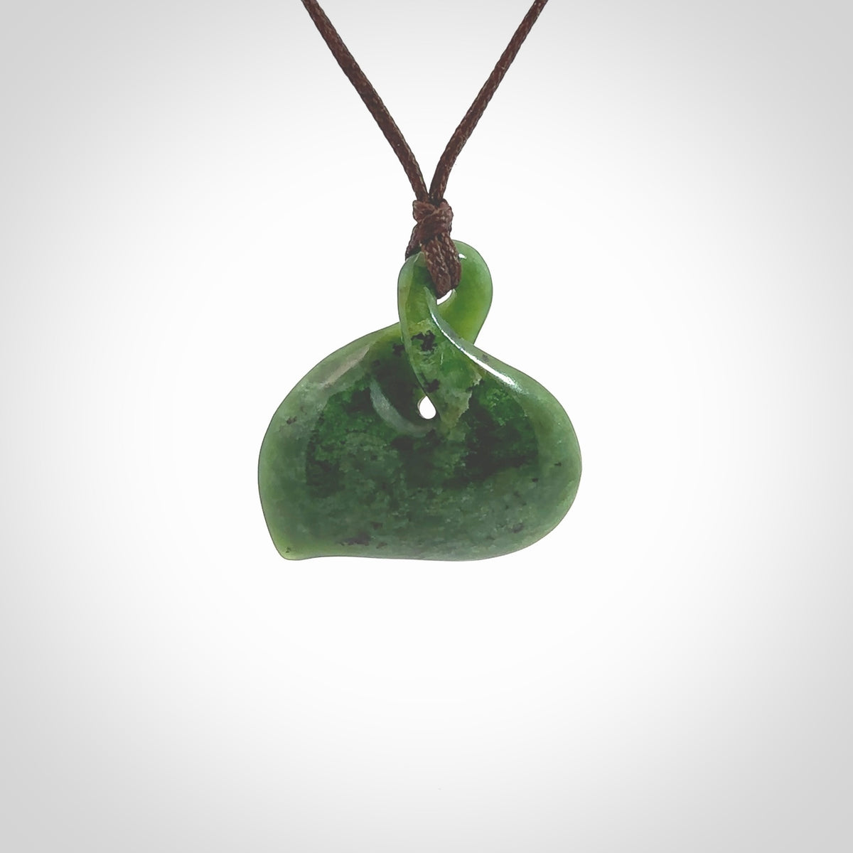Hand carved New Zealand jade, single twist pendant. Maori pikorua pendant hand carved in New Zealand. Made by NZ Pacific, jade jewellery for sale online. One only hand made by Ross Crump.