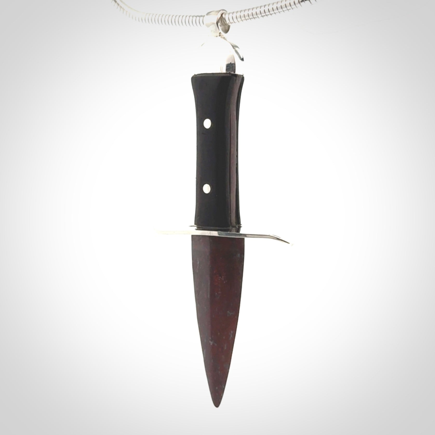 A striking hand carved dagger pendant. These are carved with a Red Jasper Stone head and a hardwood handle. It is provided with a Sterling Silver chain. We ship these worldwide with express courier.