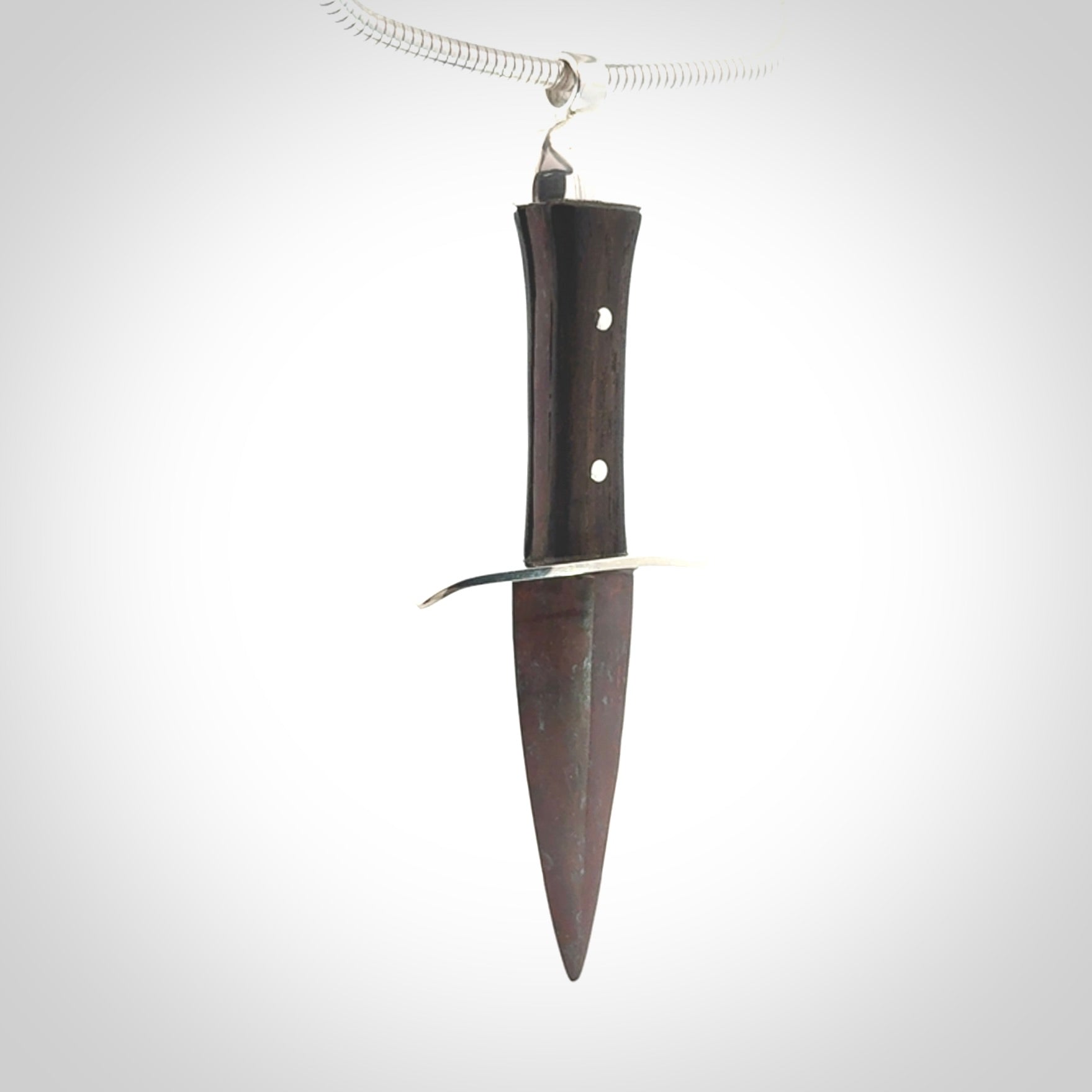 A striking hand carved dagger pendant. These are carved with a Red Jasper Stone head and a hardwood handle. It is provided with a Sterling Silver chain. We ship these worldwide with express courier.