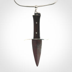 A striking hand carved dagger pendant. These are carved with a Red Jasper Stone head and a hardwood handle. It is provided with a Sterling Silver chain. We ship these worldwide with express courier.