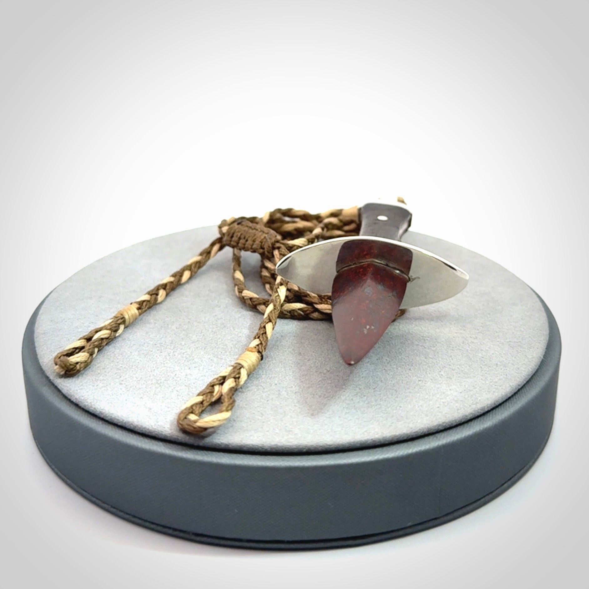 A striking hand carved knife pendant. These are carved with a Red Jasper Stone head and a hardwood handle. The cords are hand plaited in our waxed polyester which is robust, strong and durable. We ship these worldwide with express courier.