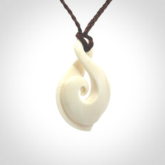 Hand carved bone twist pendant hand made by Peter Mitchell in New Zealand. This bone twist is provided with an adjustable brown cord and packaged in a woven kete pouch.
