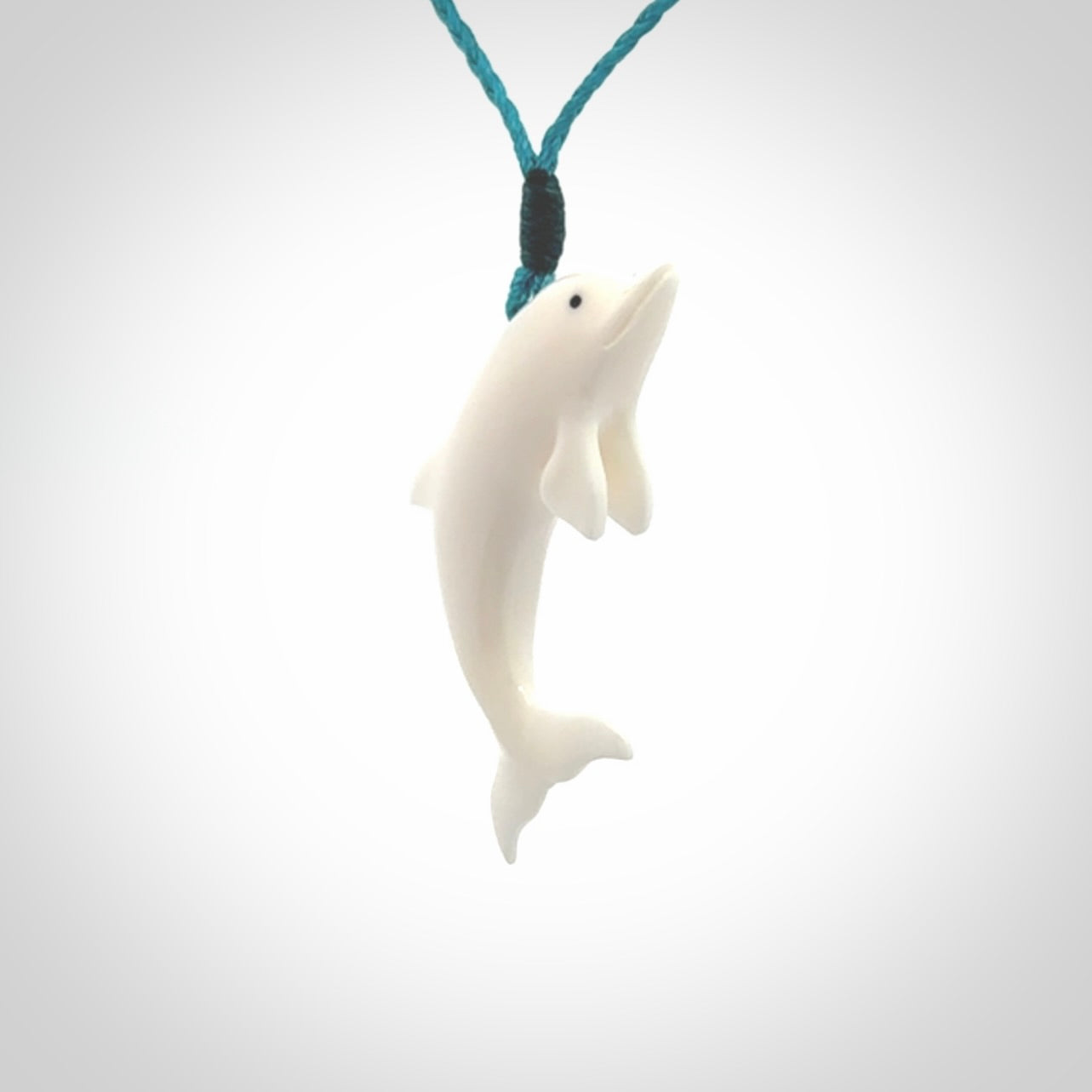 Hand made Bone dolphin pendant carved for men and women. Hand carved Bone dolphin with adjustable cord. Gifts for lovers of dolphins and art to wear. Free delivery worldwide.
