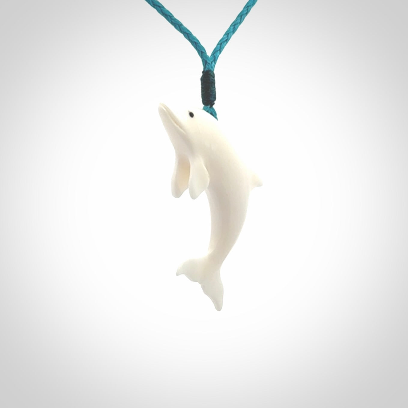 Hand made Bone dolphin pendant carved for men and women. Hand carved Bone dolphin with adjustable cord. Gifts for lovers of dolphins and art to wear. Free delivery worldwide.