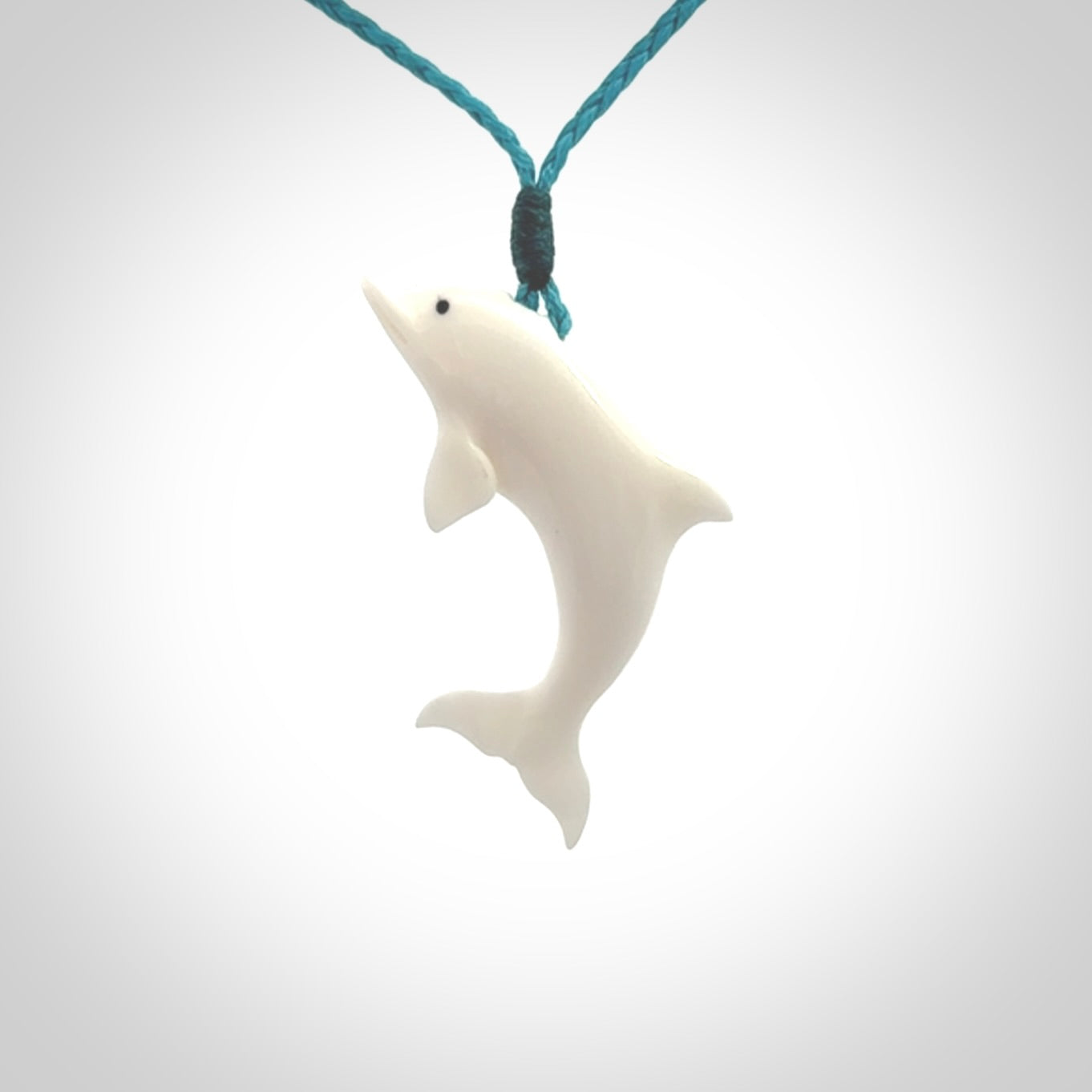 Hand made Bone dolphin pendant carved for men and women. Hand carved Bone dolphin with adjustable cord. Gifts for lovers of dolphins and art to wear. Free delivery worldwide.