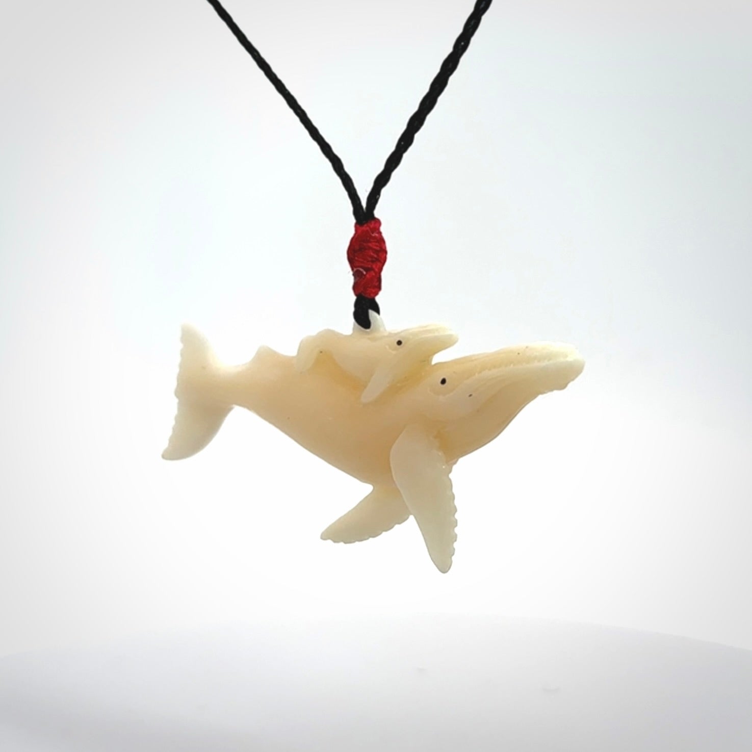 Hand carved bone whale and whale calf pendant