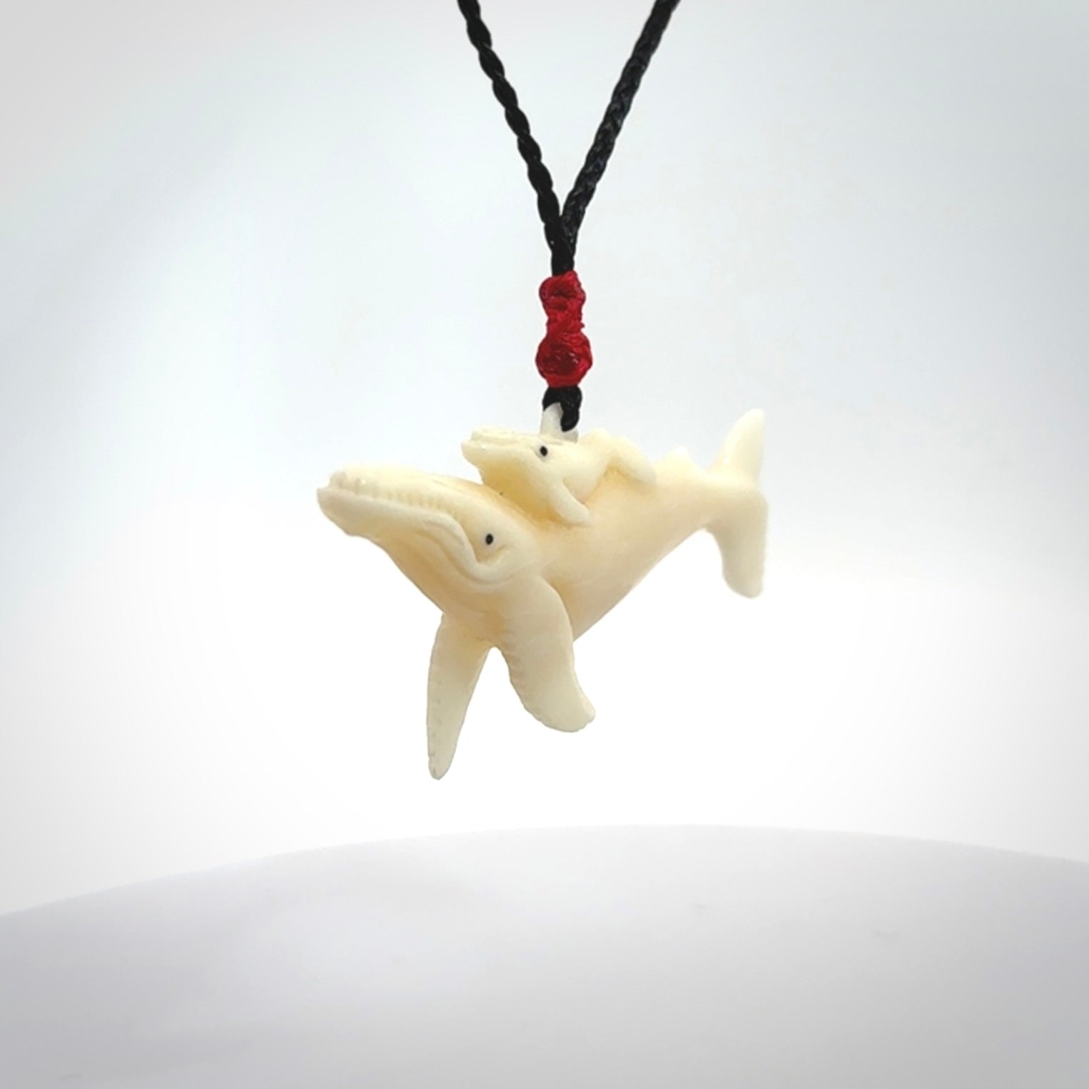 Hand carved bone whale and whale calf pendant